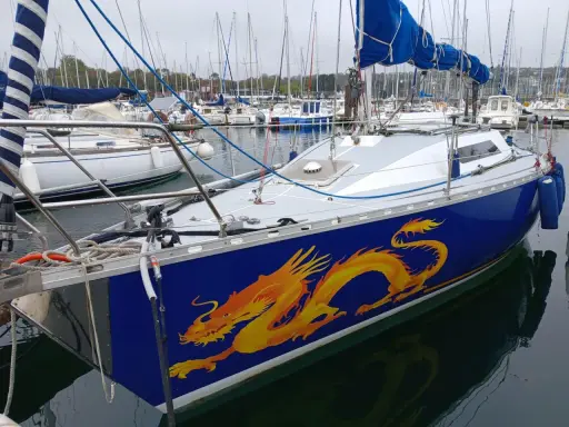 Voilier bleu orné d'un dragon jaune vif, prêt à naviguer. Les premiers 32 avis sont positifs.