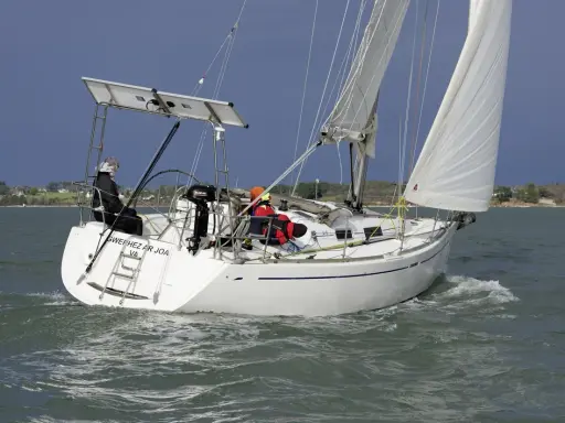 Voilier Dufour 34 en navigation, voiles blanches gonflées par le vent. La fiche technique de ce bateau est impressionnante.
