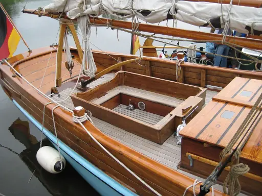 Le cockpit bateau en bois verni, avec ses cordages et sa bouée blanche, prêt pour une nouvelle aventure.