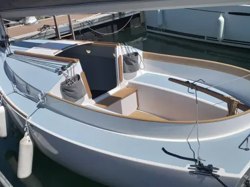 Un voilier Pabouk 700 bleu clair et blanc, prêt à naviguer, amarré à quai.