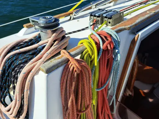 Sur un voilier, la différence entre drisse et écoute est claire : les drisses hissent les voiles, les écoutes les règlent. Ici, des cordages colorés attendent leur usage.