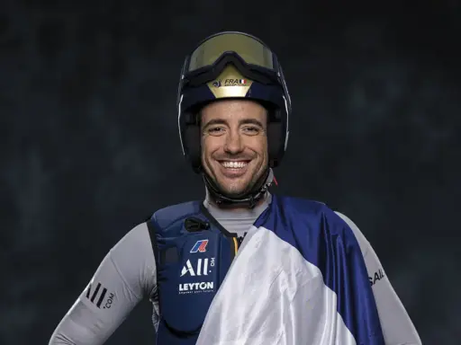 Quentin Delapierre, souriant, porte un casque de voile et une tenue de sport.