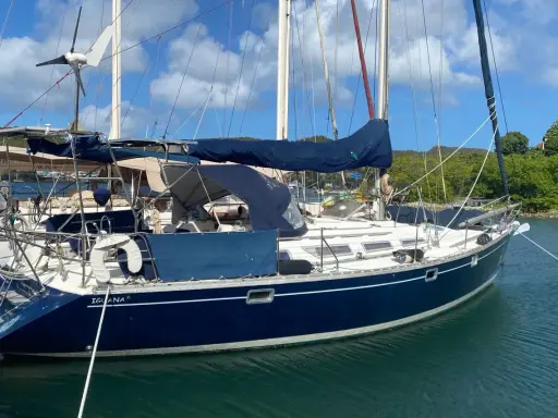 Voilier bleu "Iguana" au mouillage, sous un ciel bleu et nuageux. La magie du soleil sur l'eau, 44 avis.