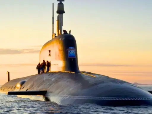 Un imposant sous-marin, potentiellement le sous-marin le plus puissant du monde, navigue sur une mer calme au coucher du soleil.