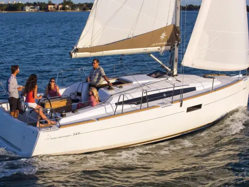 Un voilier Sun Odyssey 349 navigue avec une famille. La fiche technique de ce bateau est idéale pour des vacances en mer.