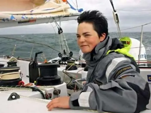 La navigatrice Ellen MacArthur, compagnon de bord sur un voilier, ajuste une voile.