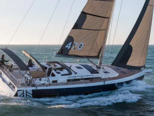 Voilier Dufour 470 en pleine navigation, voiles noires et blanches portant le numéro 470.