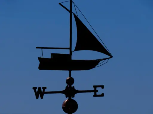 Girouette en forme de voilier, indiquant le vent. Un outil de météo IA pour naviguer.