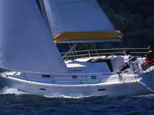 Voile blanche gonflée sur un voilier Oceanis 331 naviguant sur une mer bleue. Avis positifs pour ce bateau.