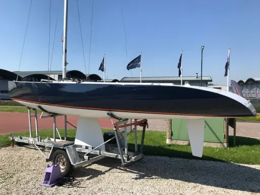 Voilier de course noir et blanc, un modèleBepox 750, sur sa remorque, prêt pour l'aventure.