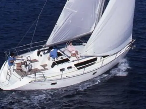 Trois personnes profitent d'une belle journée en mer à bord de voiliers occasion 9 10 mètres. Le bateau blanc navigue sur des eaux bleues.
