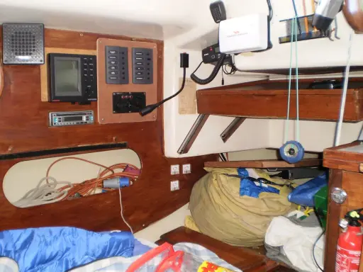 Aménagement bateau : tableau électrique, GPS, radio, compas et rangement.