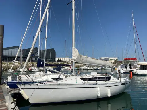 Voiliers blancs amarrés dans un port sous un ciel bleu. L'ambiance est paisible, feeling 920 avis.