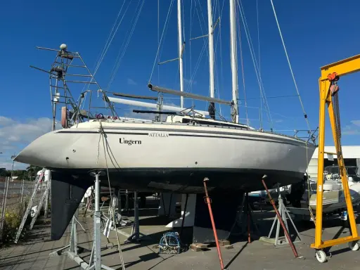 Voilier Attalia 32 "Ungern" sur bers, prêt pour sa fiche technique. Mât, voiles et quille visibles.