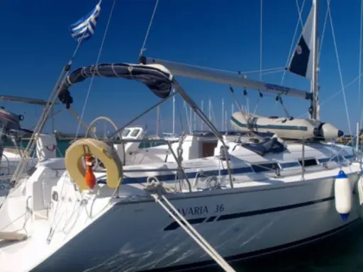 Voilier Bavaria 36 blanc amarré, pavillon grec, pare-battages bleus et blancs.