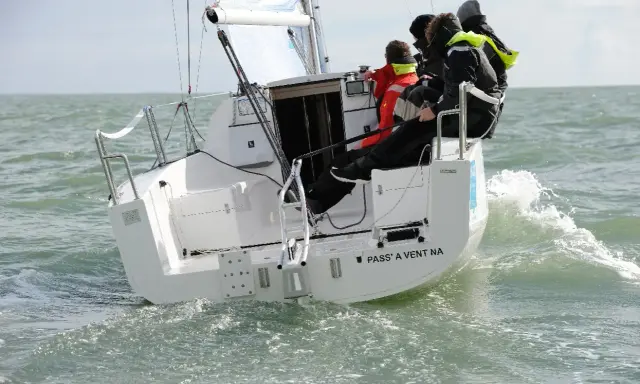 Équipage sur un voilier polonais transportable naviguant sur une mer agitée.