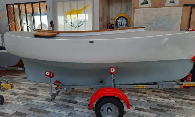Bateau blanc sur remorque, prêt pour l'aventure. Le drapeau chypriote flotte, rappelant les eaux bleues. Un **pabouk 360** attend son prochain voyage.