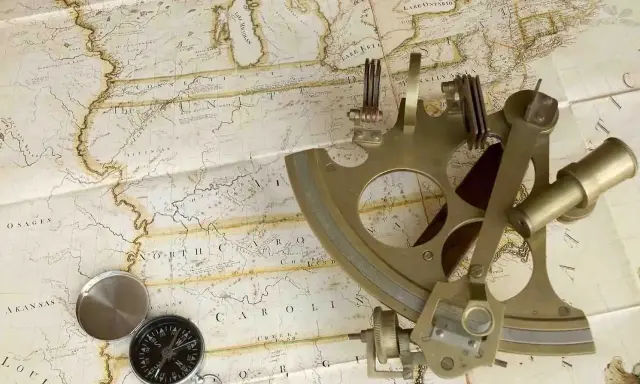 Un sextant et une boussole sur une carte ancienne, évoquant la navigation et l'exploration.