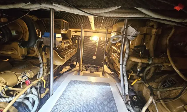 Vue de la salle des machines d'un bateau, avec deux moteurs inboard jaunes. L'entretien régulier est essentiel pour la durée de vie d'un moteur inboard.