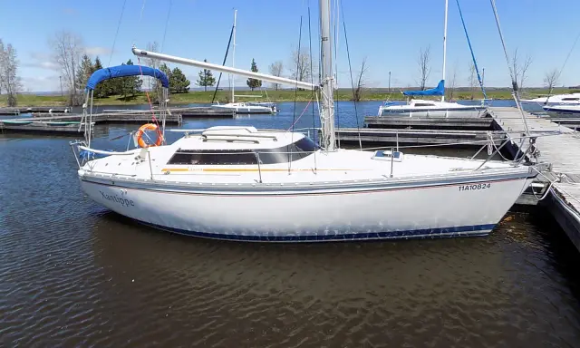 Un voilier blanc, le "Xantippe", est amarré dans un port. Ce bateau de fantasia attend de prendre le large.