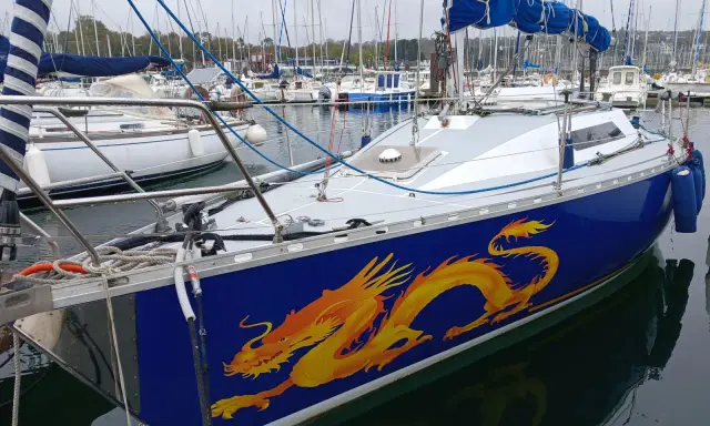 Voilier bleu orné d'un dragon jaune vif, prêt à naviguer. Les premiers 32 avis sont positifs.