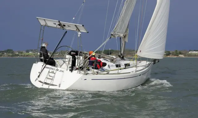 Voilier Dufour 34 en navigation, voiles blanches gonflées par le vent. La fiche technique de ce bateau est impressionnante.
