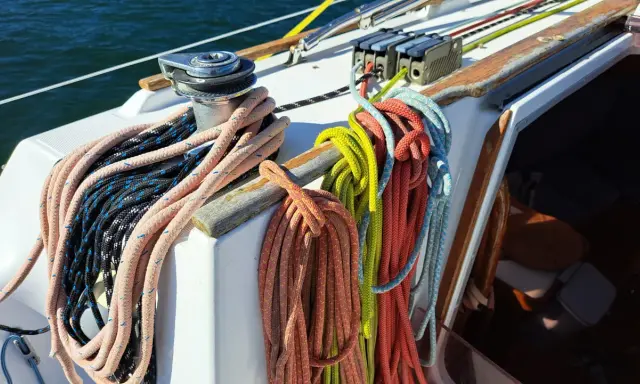 Sur un voilier, la différence entre drisse et écoute est claire : les drisses hissent les voiles, les écoutes les règlent. Ici, des cordages colorés attendent leur usage.