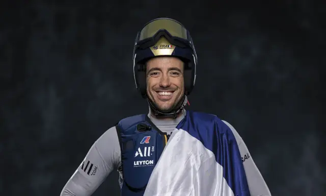 Quentin Delapierre, souriant, porte un casque de voile et une tenue de sport.