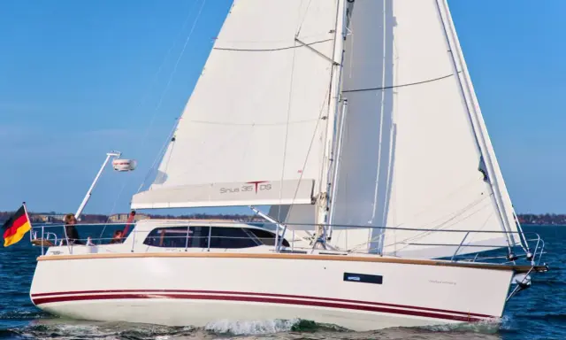 Voilier blanc Sirius 35 DS naviguant sur une mer bleue, avec le drapeau allemand à l'avant.