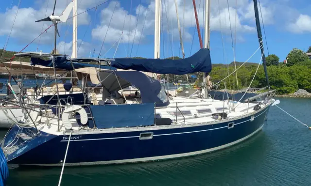 Voilier bleu "Iguana" au mouillage, sous un ciel bleu et nuageux. La magie du soleil sur l'eau, 44 avis.