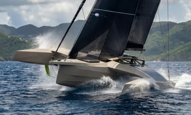 Un trimaran futuriste fend les vagues, ses voiles noires déployées. Un spectacle impressionnant, digne d'un "etape 21i avis" de course.