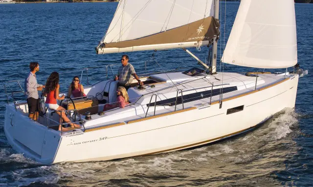Un voilier Sun Odyssey 349 navigue avec une famille. La fiche technique de ce bateau est idéale pour des vacances en mer.