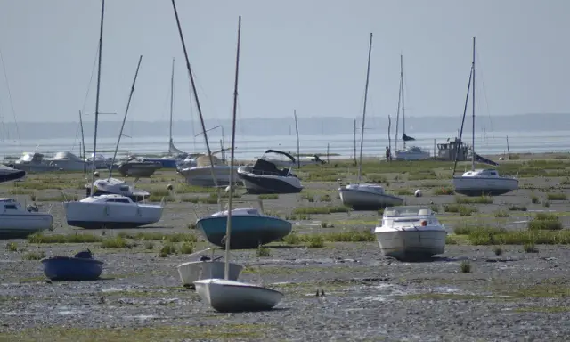 Échoués sur la vase, plusieurs voiliers et bateaux à moteur attendent la marée. Une scène typique de la fiche technique d'un port, avec des bateaux de type Edel 4.
