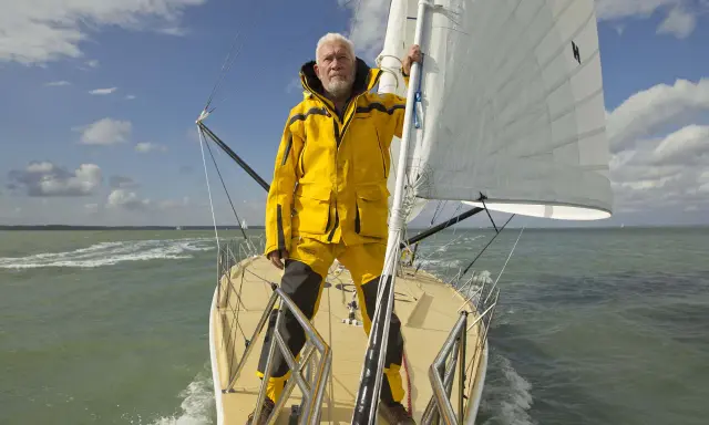 Robin Knox-Johnston, le légendaire navigateur, sur son voilier, prêt pour une nouvelle aventure en mer.