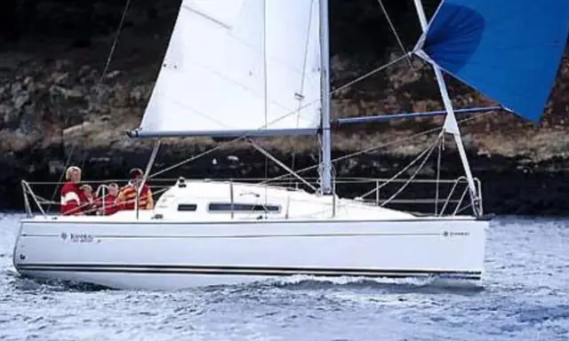 Un voilier Sun Odyssey 26 navigue sur une mer calme, avec des personnes à bord. Les avis sur ce bateau sont généralement positifs.