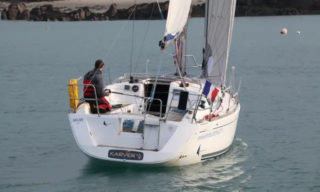Un voilier Dufour 325 Grand Large navigue, un homme à la barre. Avis de navigation en mer.