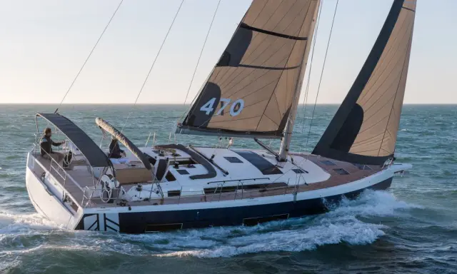 Voilier Dufour 470 en pleine navigation, voiles noires et blanches portant le numéro 470.