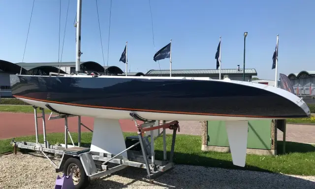 Voilier de course noir et blanc, un modèleBepox 750, sur sa remorque, prêt pour l'aventure.