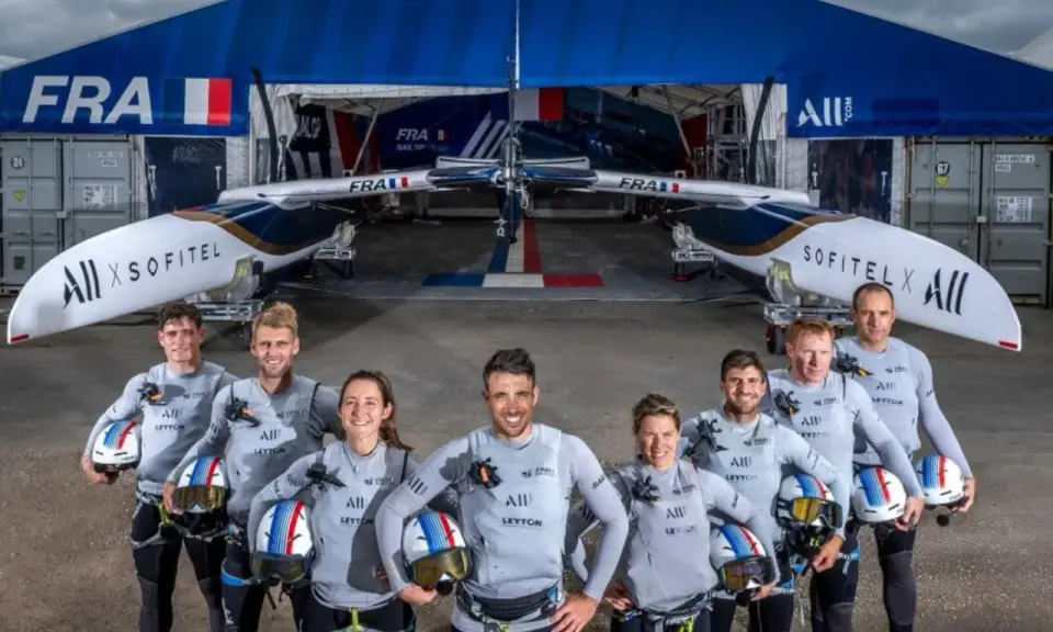 L'équipe française du SailGP France pose fièrement devant son catamaran, prête à conquérir les océans.