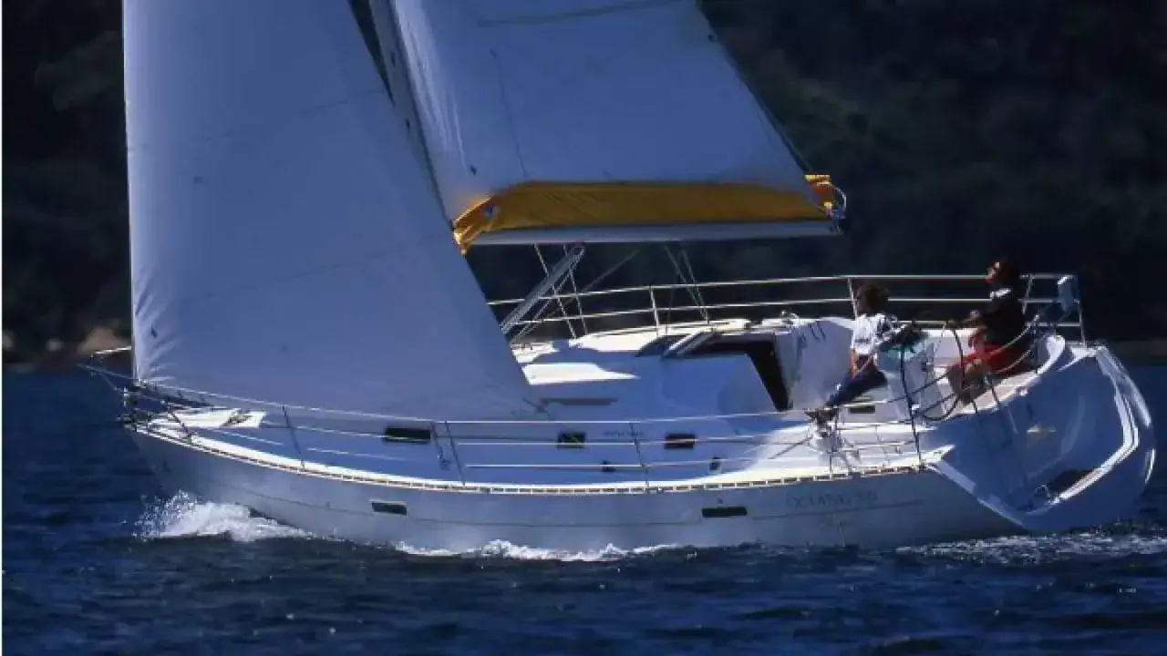 Voile blanche gonflée sur un voilier Oceanis 331 naviguant sur une mer bleue. Avis positifs pour ce bateau.