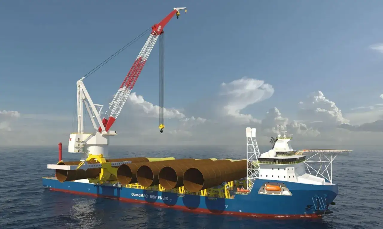 Bateau grue transportant des &eacute;l&eacute;ments de fondation pour une &eacute;olienne en mer. Le navire est &eacute;quip&eacute; d'une grue imposante et de plusieurs tubes cylindriques.