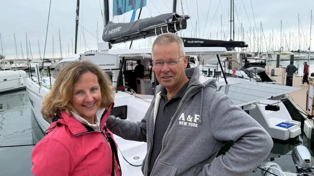 Xavier Desmarest et sa compagne souriants devant leur catamaran Outremer.
