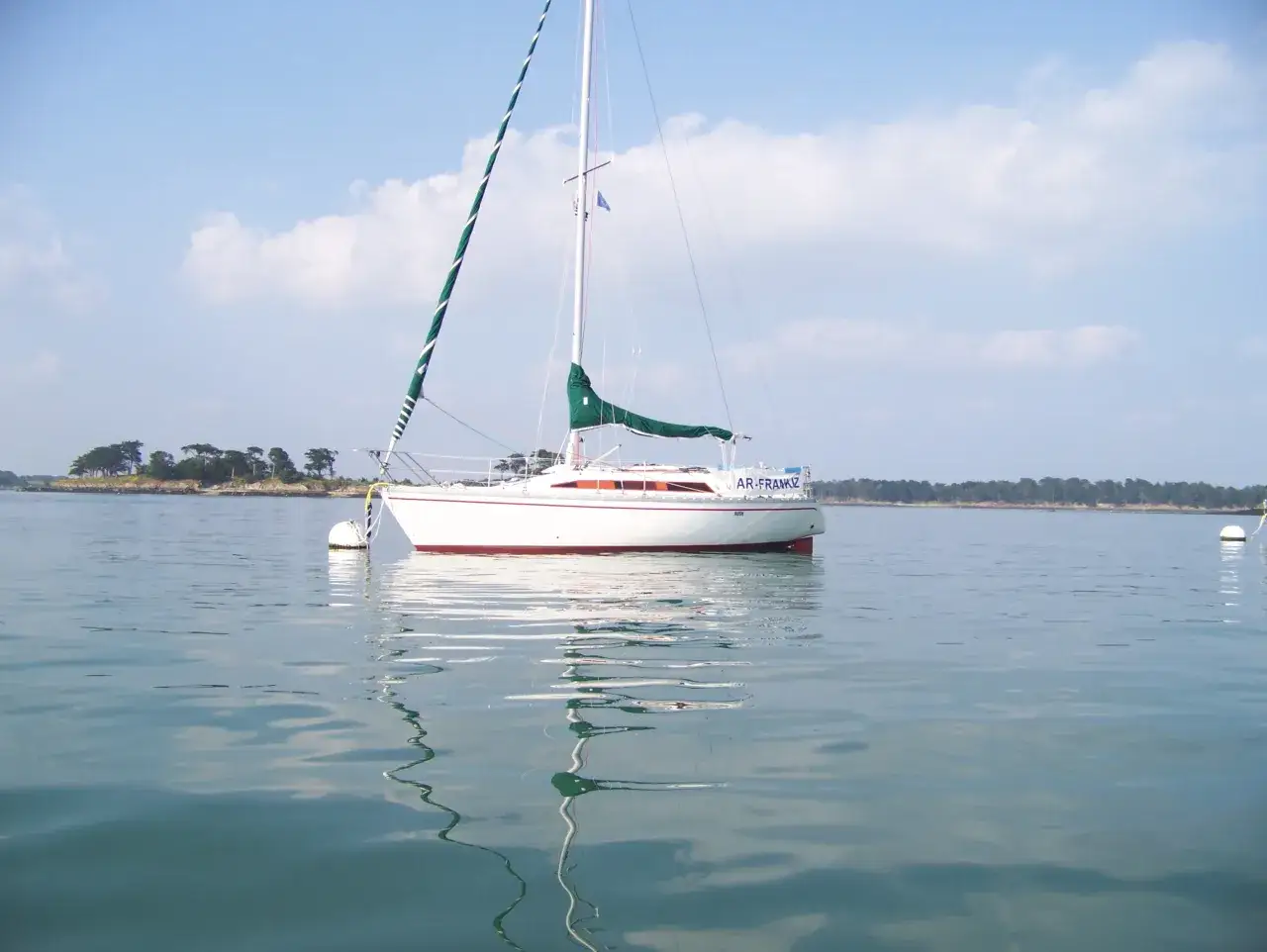 Un voilier blanc avec une voile verte, 