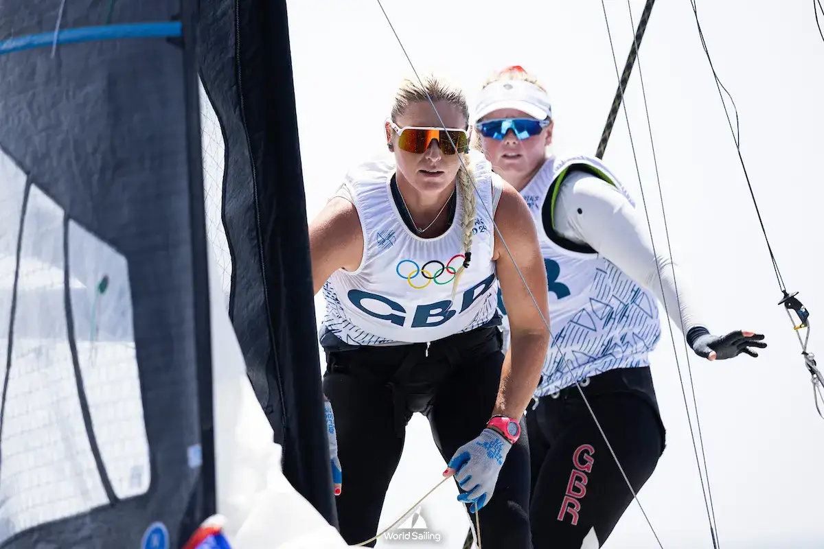 Manon Audinet et sa co&eacute;quipi&egrave;re concentr&eacute;es sur la r&eacute;gate, voiles et cordages en premier plan.