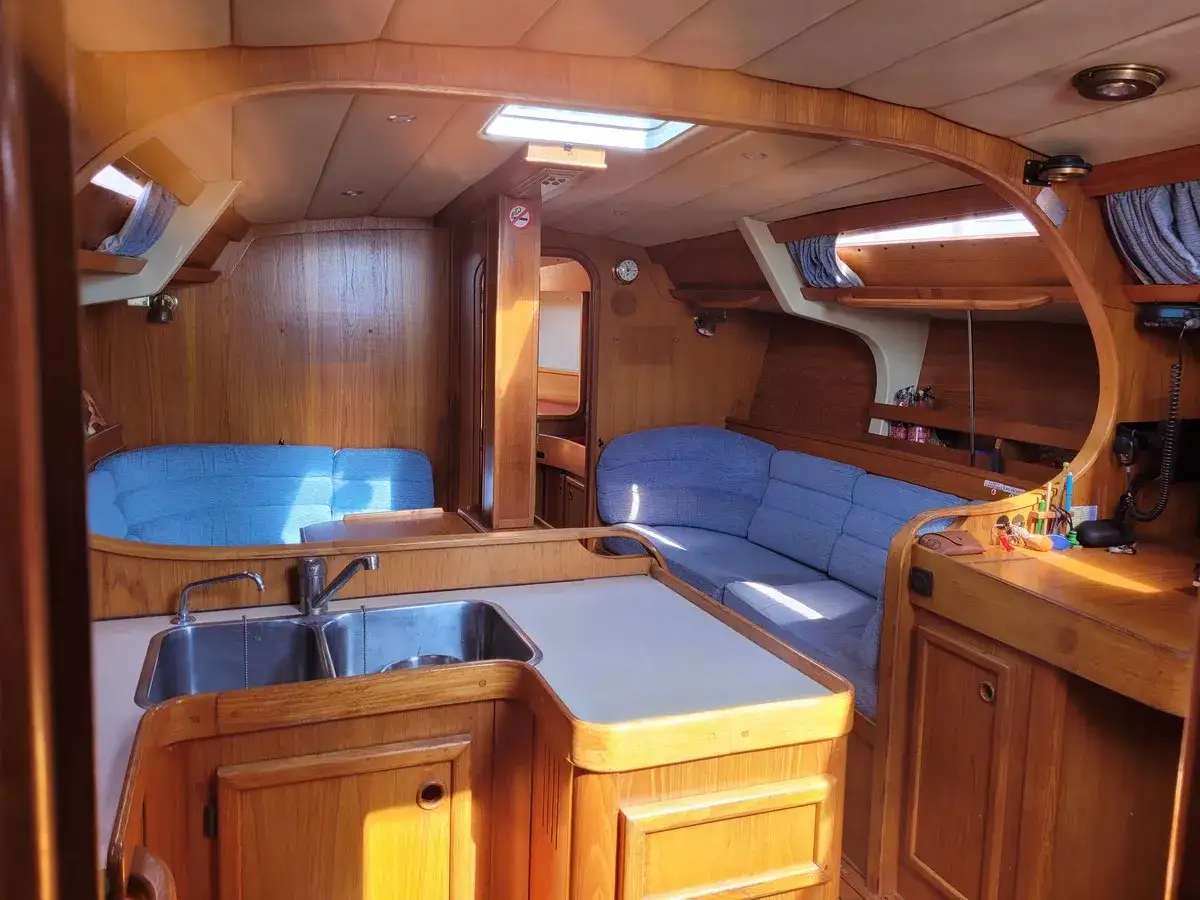 Intérieur chaleureux d'un voilier, avec banquettes bleues et cuisine. Une légende du soleil, 41 avis, pourrait raconter l'histoire de ce bateau.