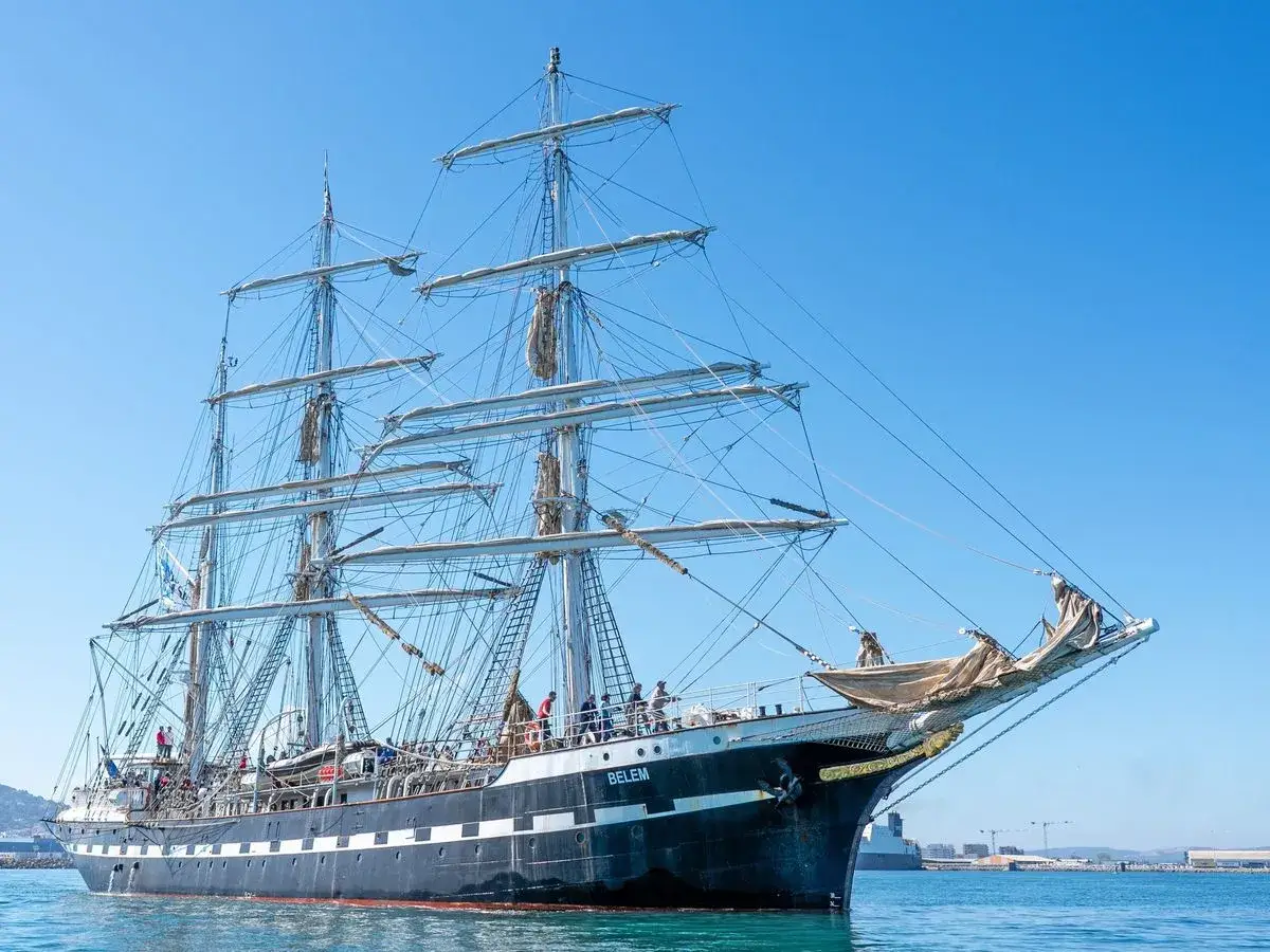 Le Belem, majestueux trois-mâts, navigue fièrement vers Bayonne, ses voiles prêtes à prendre le vent.