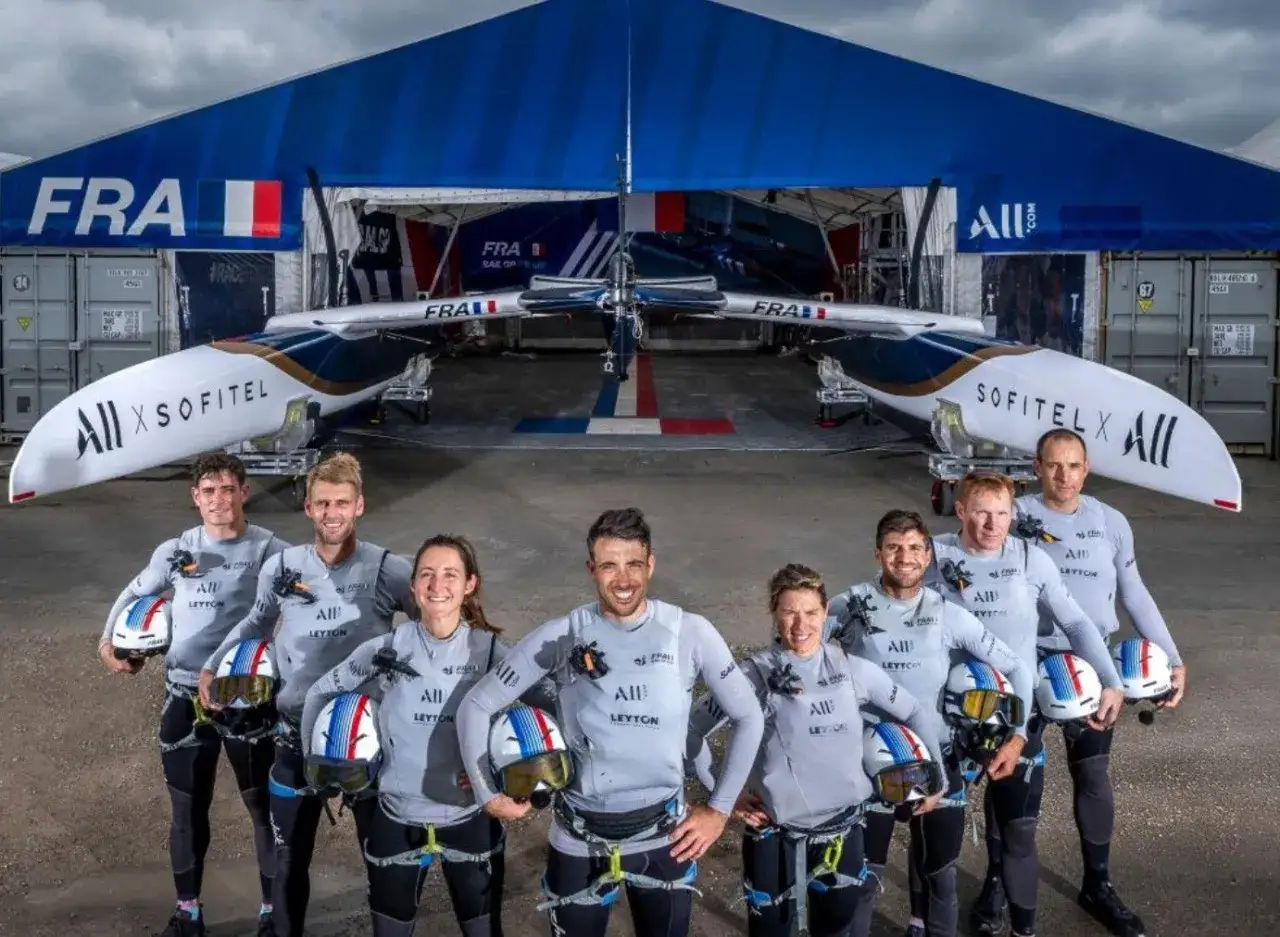 L'équipe française du SailGP France pose fièrement devant son catamaran, prête à conquérir les océans.