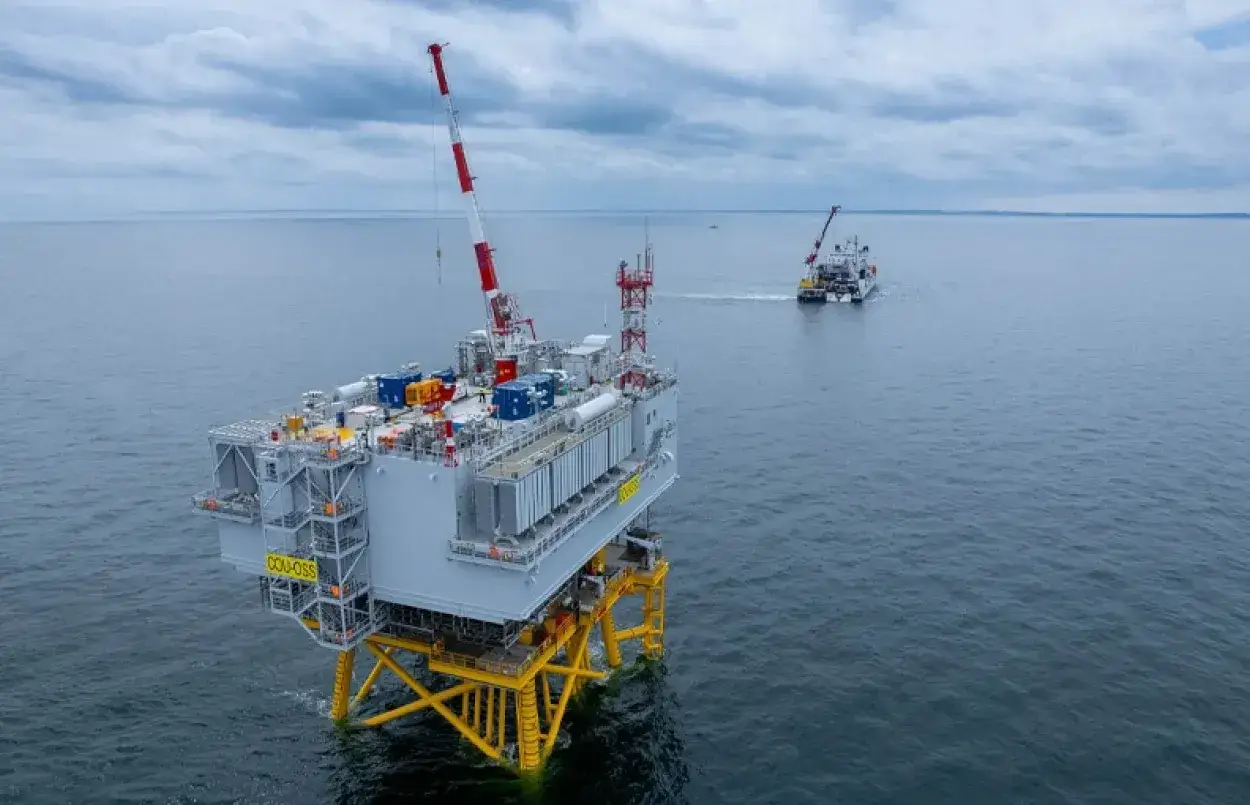 Plateforme jackup en mer, avec un navire d'assistance en arrière-plan.