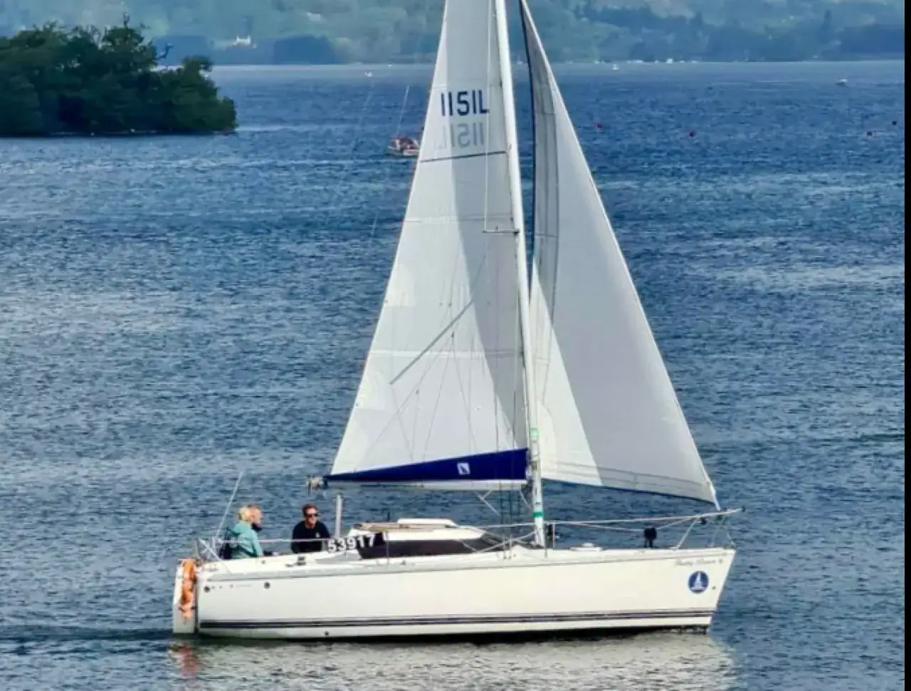 Voilier blanc naviguant sur l'eau bleue, avec deux personnes à bord. Un jour tonic, 23 avis sur la météo.