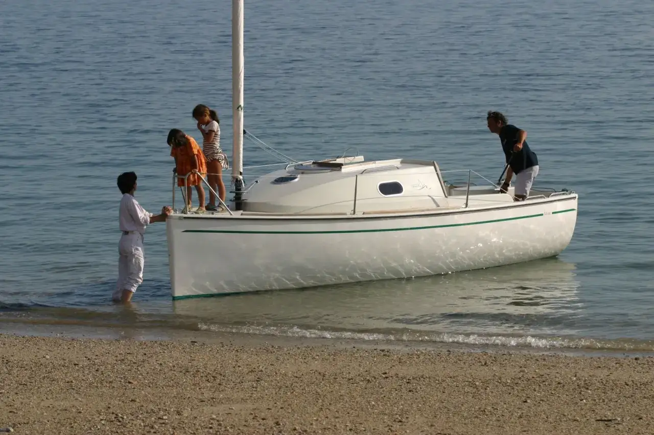 Une famille prépare leur voilier pour une sortie en mer. L'ikone voilier est prêt à naviguer.
